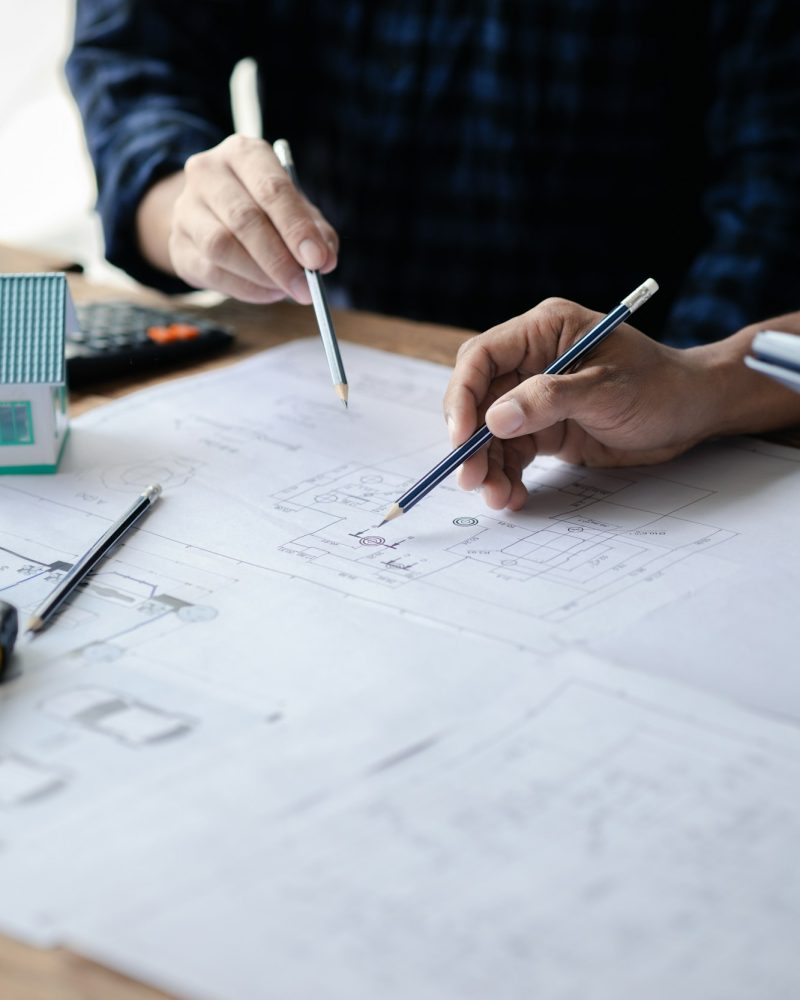 The home design architects are reviewing the house plan draft, the project commissioned by the clien