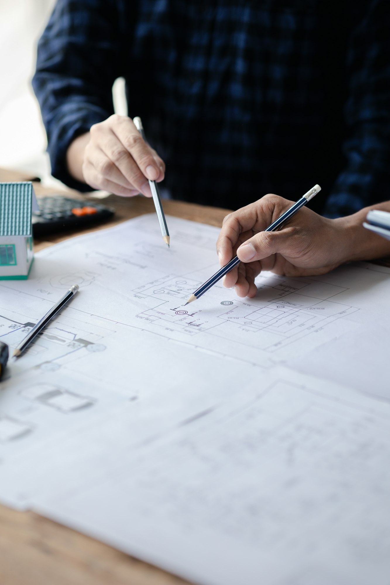 The home design architects are reviewing the house plan draft, the project commissioned by the clien